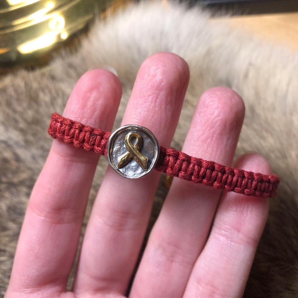 Braided red fabric cancer awareness bracelet with sterling brass ribbon charm